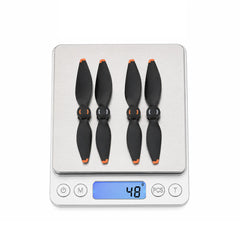 DJI Mavic 4 Pro propellers displayed on scale showing net weight 48g