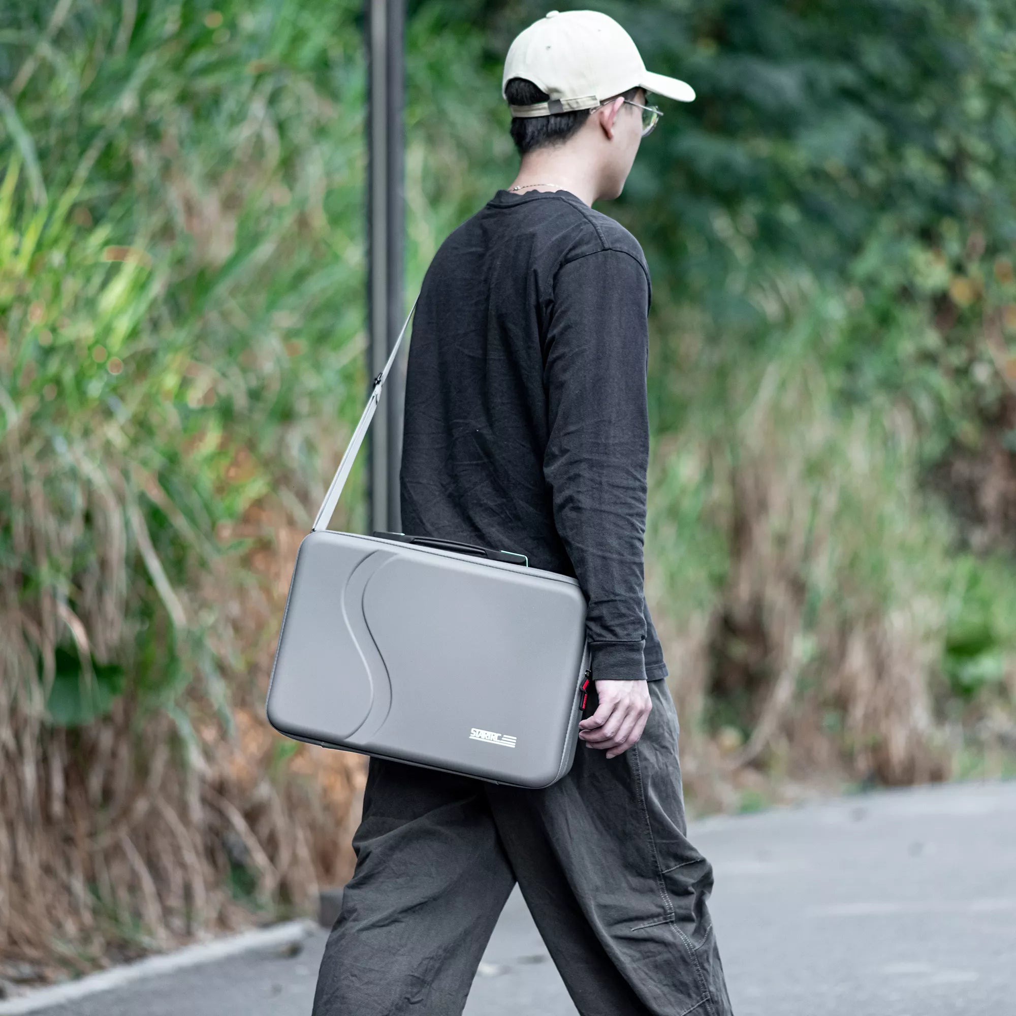 Dual carrying modes: retractable handle and shoulder strap for DJI RS 5 bag.