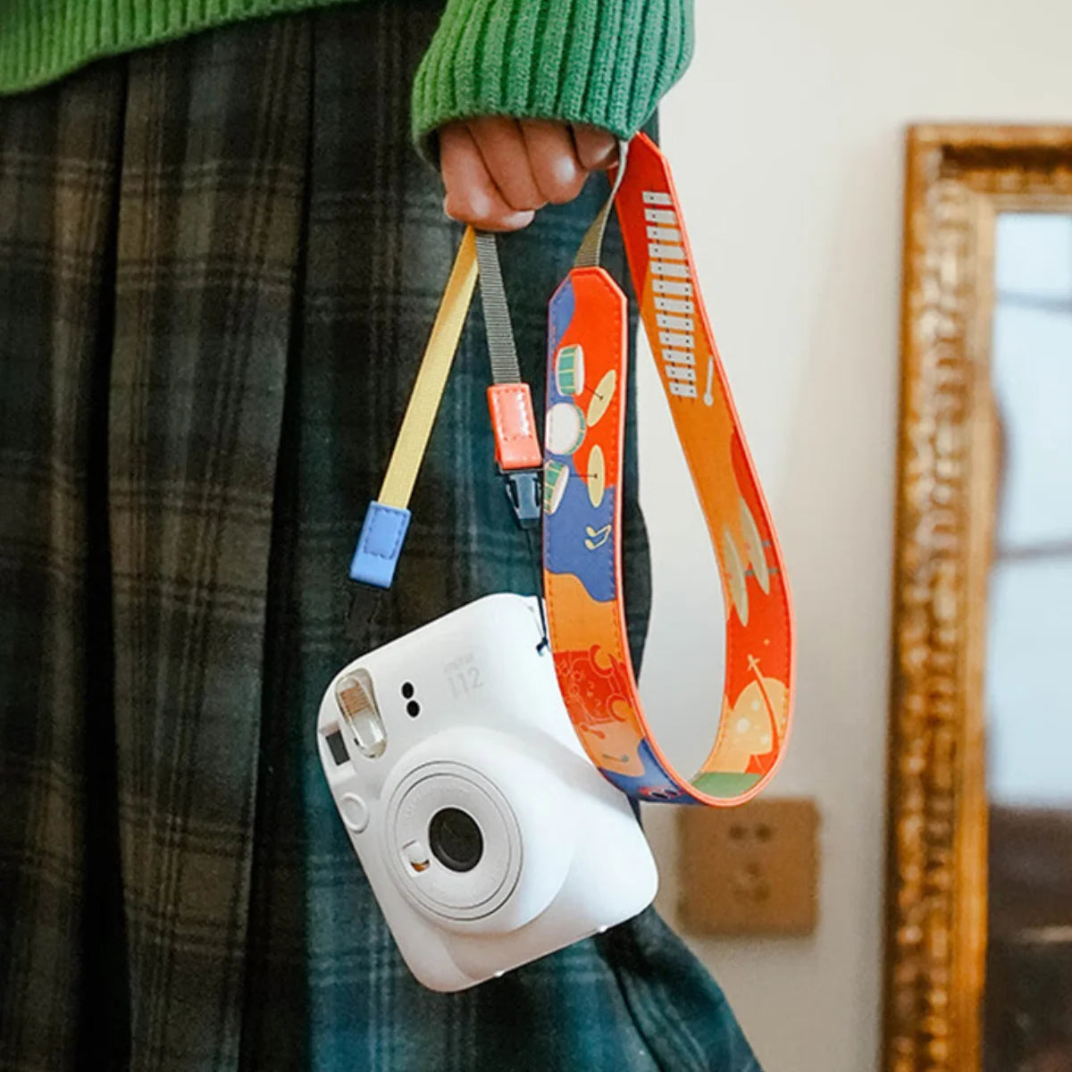 Retro color-block camera strap mounted on a silver mirrorless camera for travel.